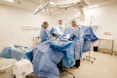 Surgical team performing a procedure in an operating room.